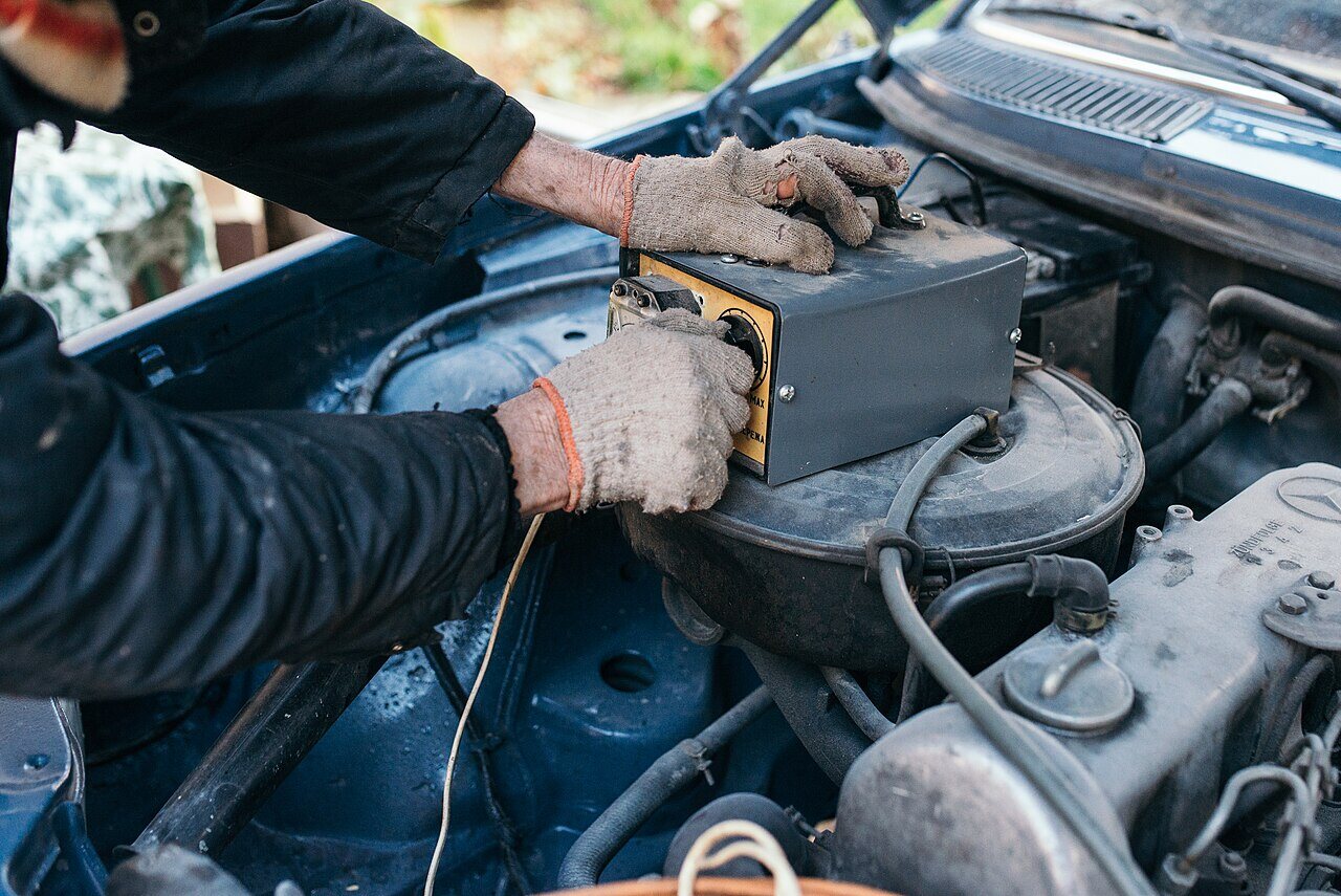 Eine 12-Volt-Autobatterie wird mit einem Messgerät geprüft.