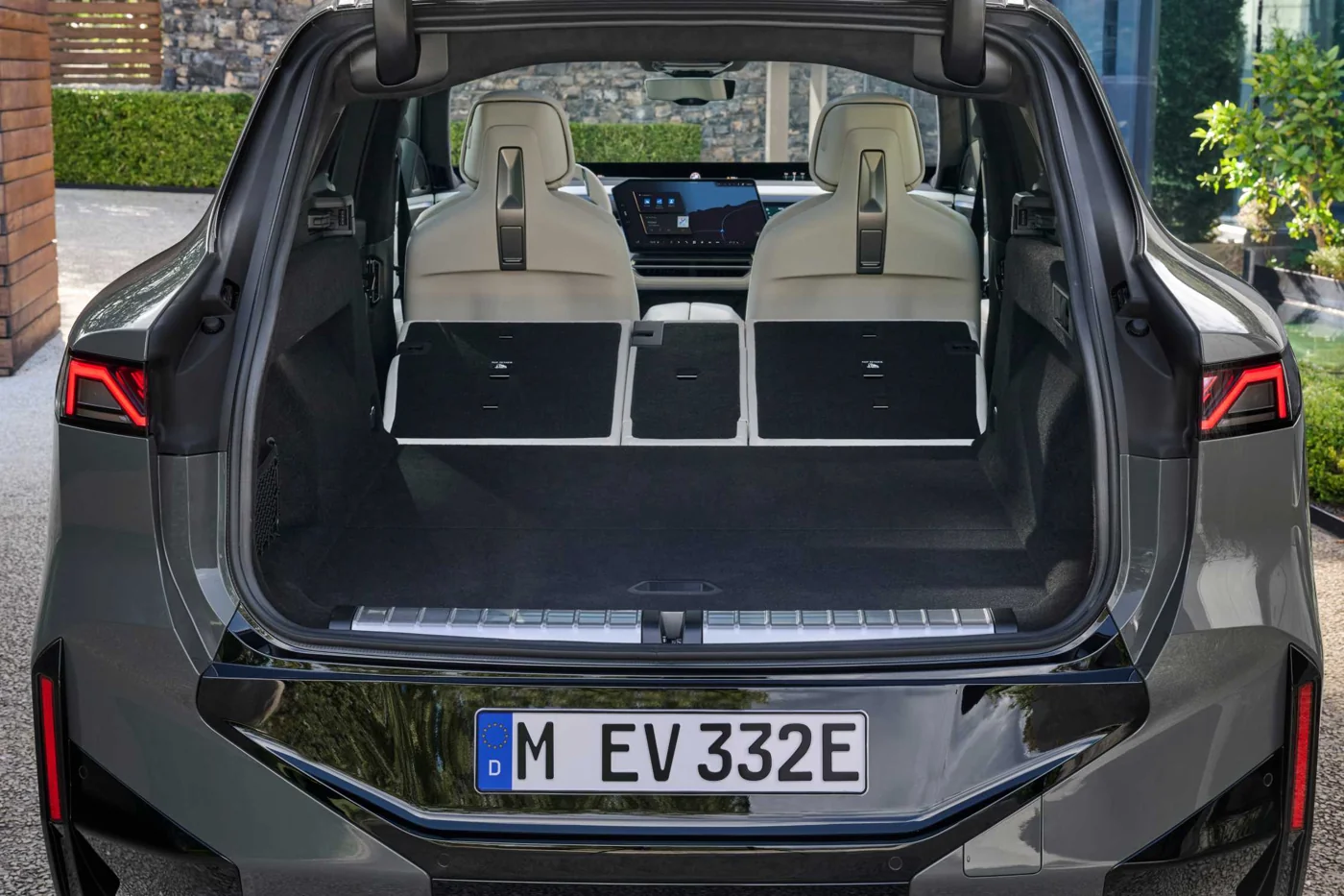 Heckansicht des BMW iX5 mit geöffneter Heckklappe und umgeklappten Rücksitzen auf einer BMW Presseaufnahme.