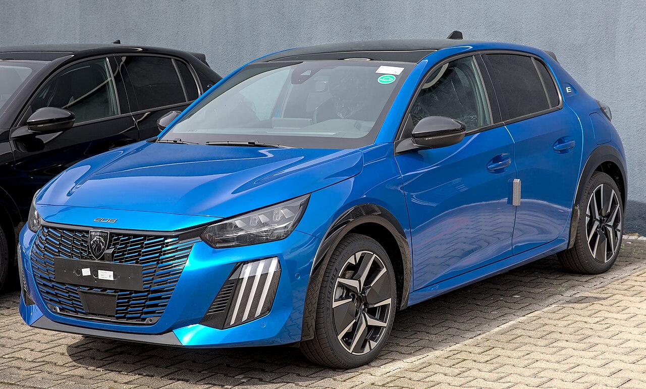 Überarbeiteter elektrischer Peugeot E-208 in blauer Lackierung, Front Seitenansicht.